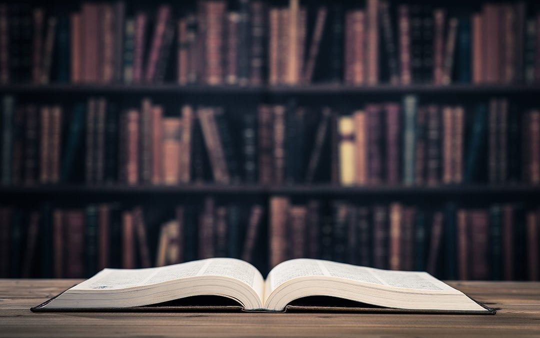 Open book on table in library